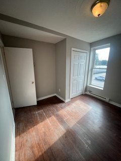 A grey room with a white closet door and a window