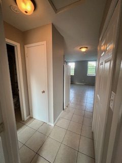 A hallway with grey walls and white doors leading to the living room
