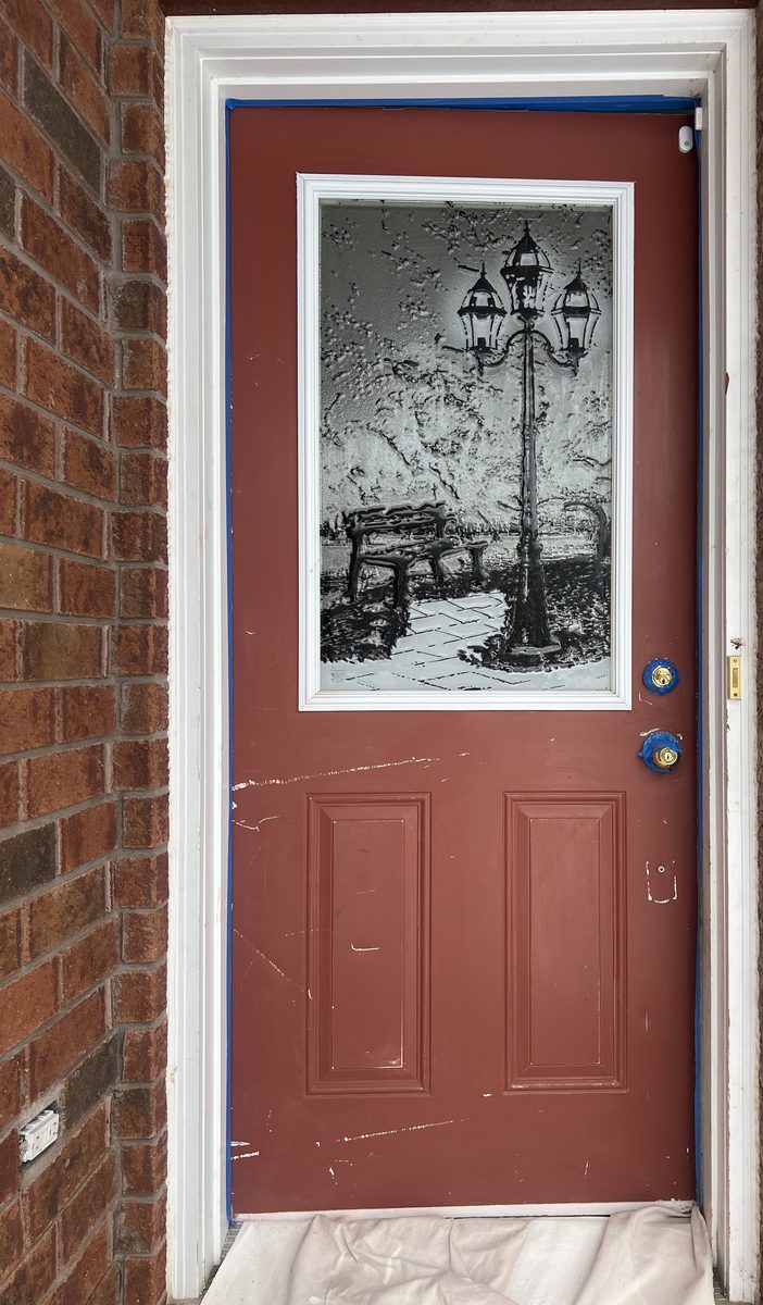 A worn red front door with a glass insert, before painting