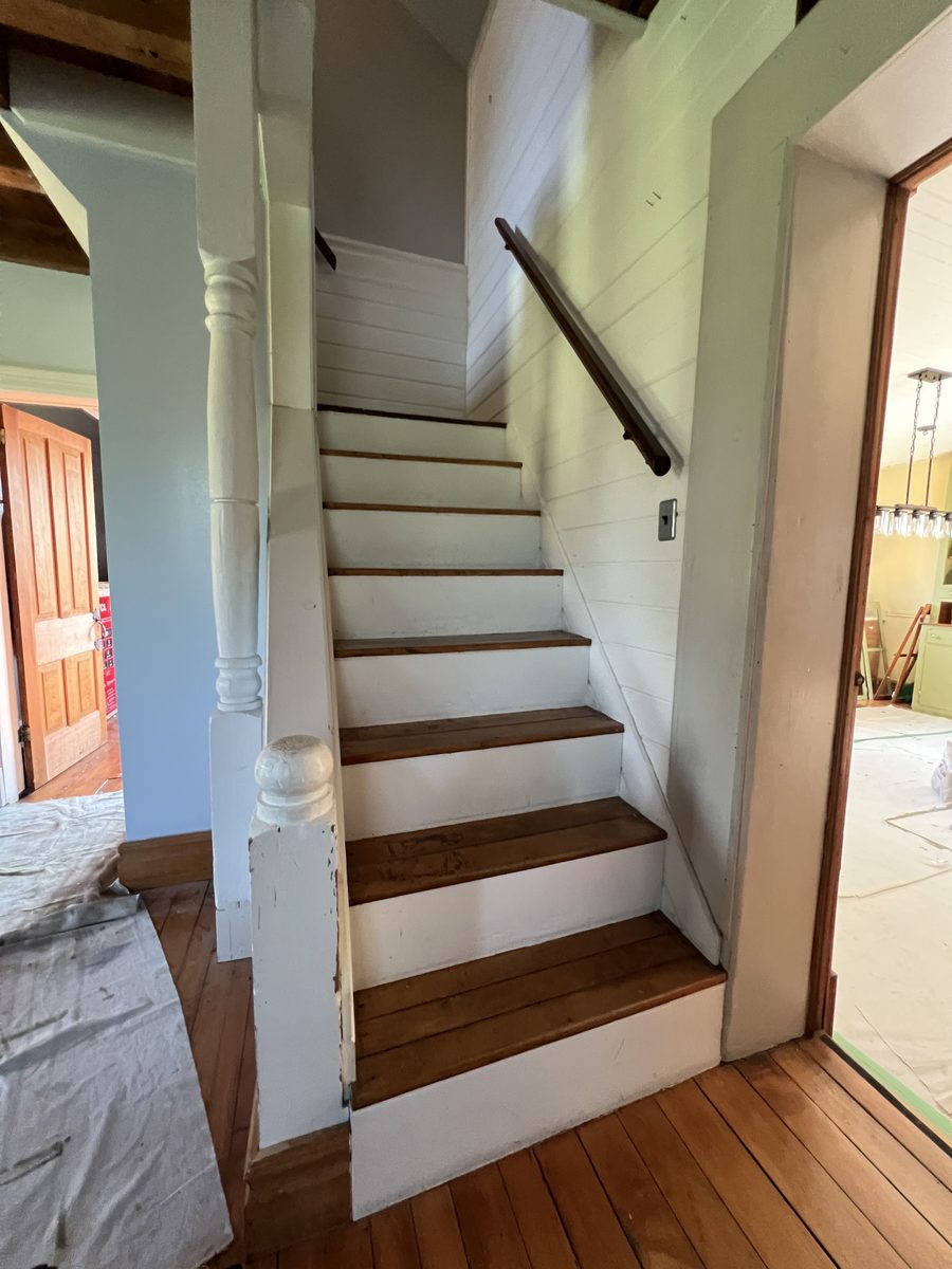 Close view of the white-painted stairs and newel post