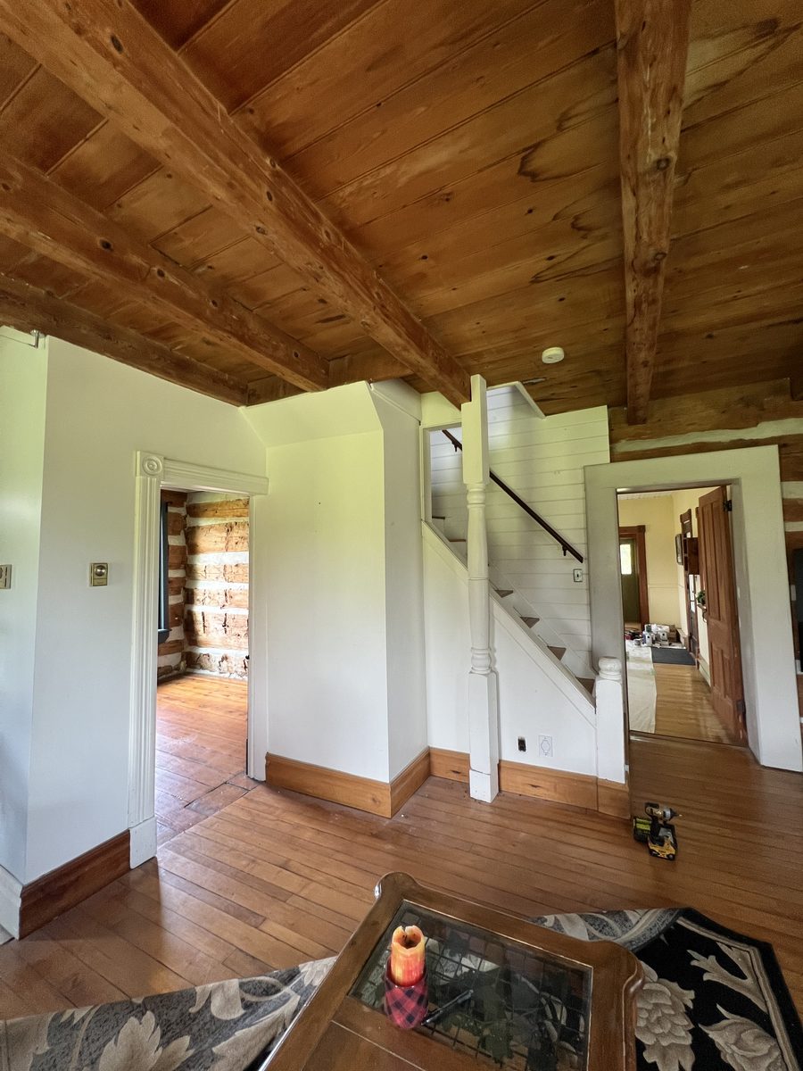 Painted walls and stairs under exposed log beams