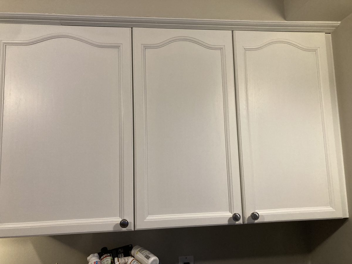 A run of three painted white upper cabinet doors